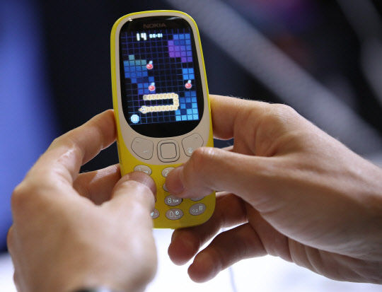 27일(현지시간) 세계 최대 모바일 전시회 '모바일 울드 콩그레스(MWC) 2017'이 열린 스페인 바르셀로나 피라 그란비아 내 노키아 부스에서 관람객이 피쳐폰인 노키아3310을 이용해 게임을 해보고 있다.      노키아3310은 최장 22시간 통화 및 한달까지 대기가 가능하다.